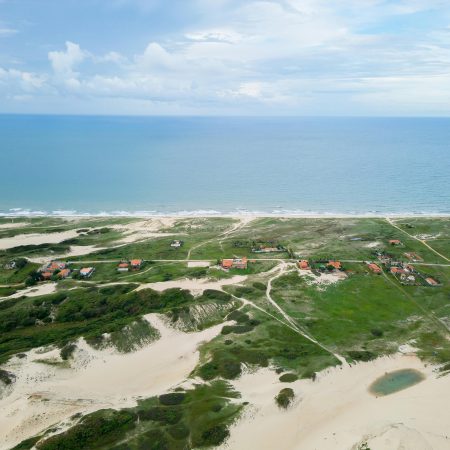 Discover the breathtaking aerial view of Fortaleza's coastline, featuring sandy dunes and lush greenery.
